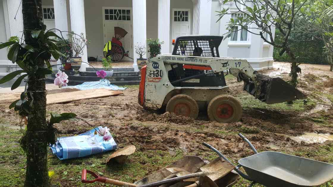 Skid-steer regrading and levelling the ground at the heritage bungalow lawn