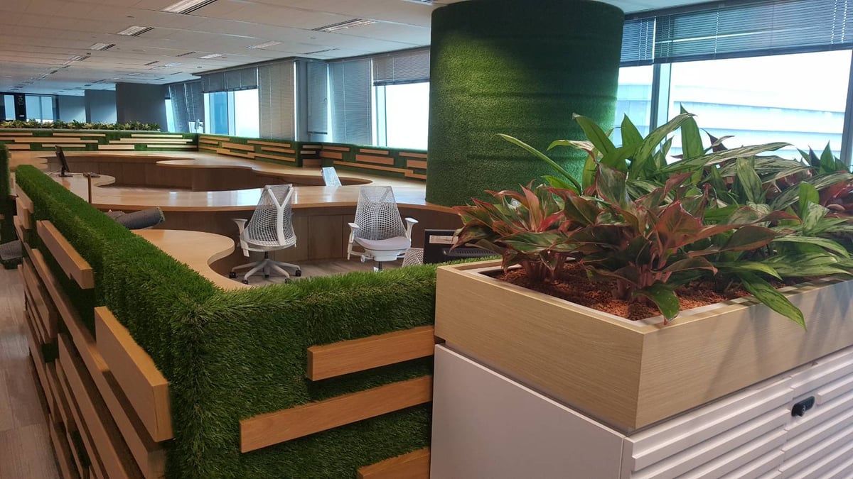 Artificial grass office landscaping with a grass-clad column and planters at Capital Tower, Singapore