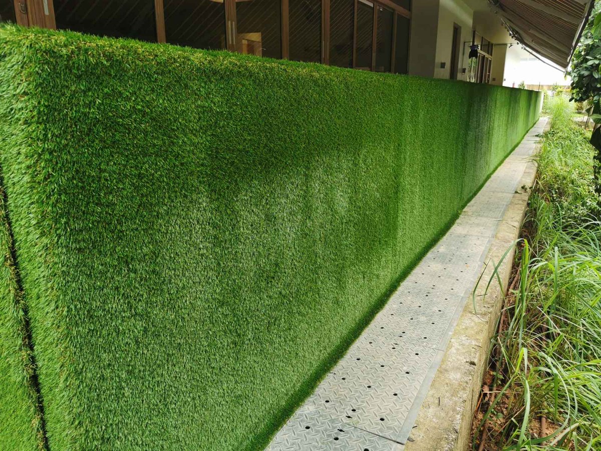 Artificial grass wrapping a full-height childcare corridor wall at Skool4Kids, Singapore