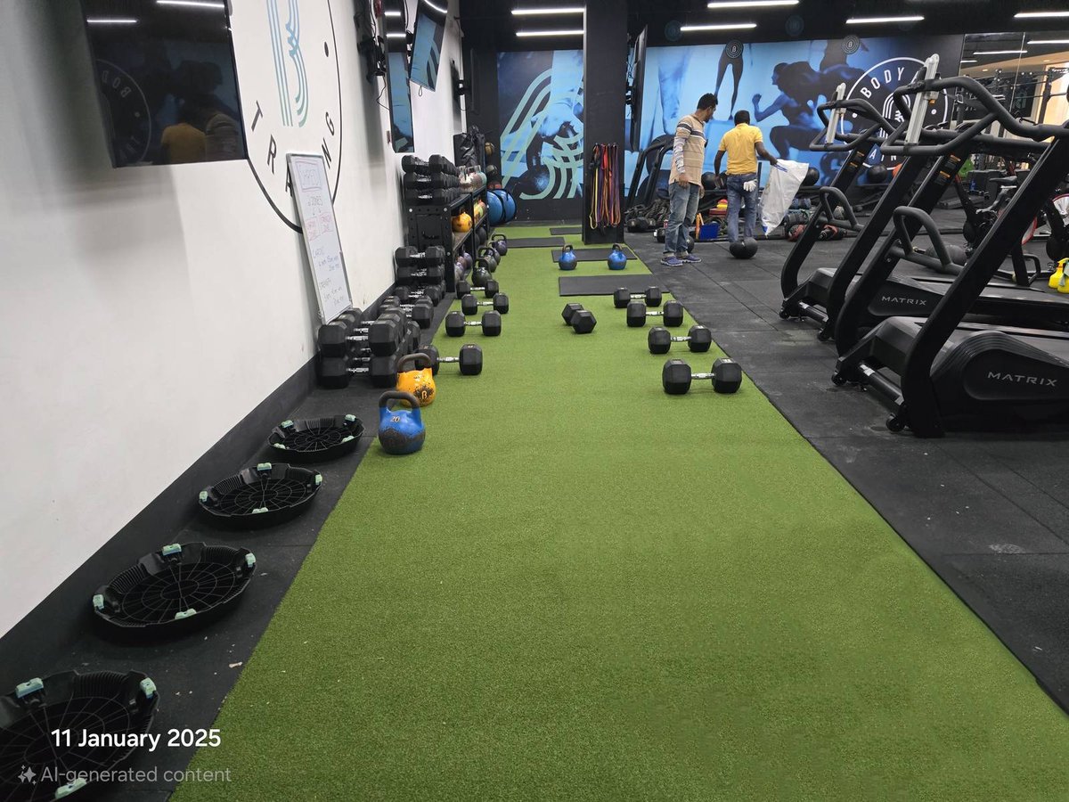Artificial grass gym floor beside dumbbell racks and treadmills at BFT Paya Lebar Kinex, Singapore