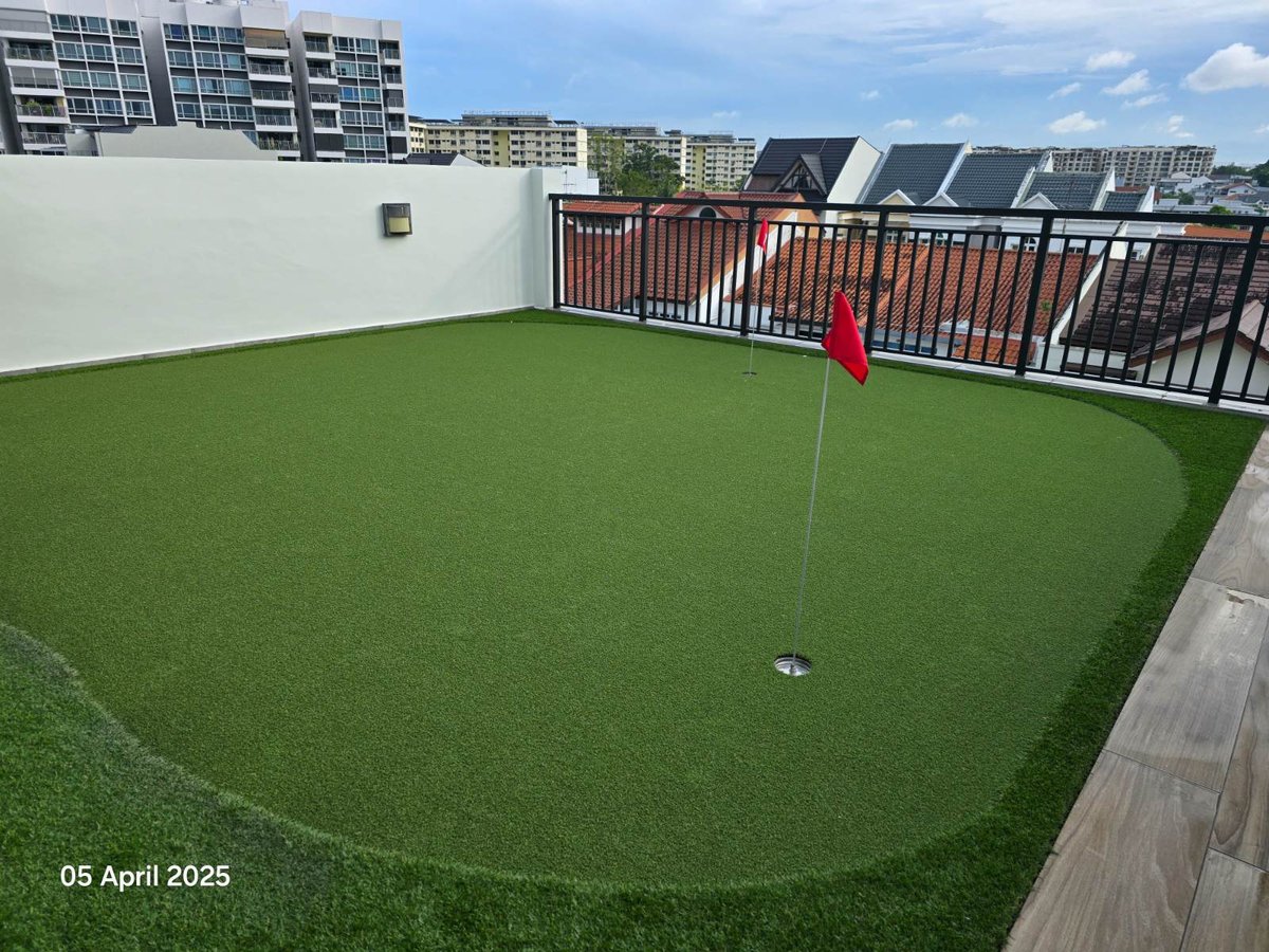 Custom-designed rooftop artificial grass putting green with red flags, Singapore