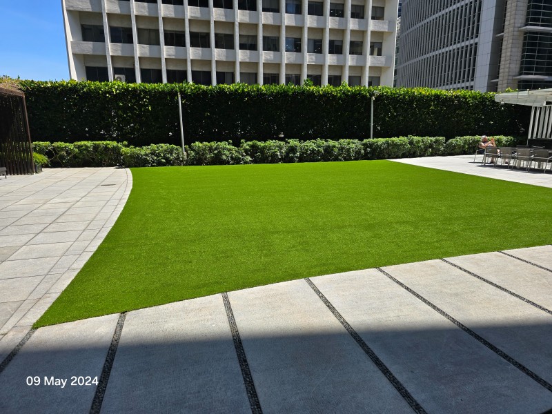The completed One Shenton rooftop lawn in premium Namgrass, framed by the CBD skyline