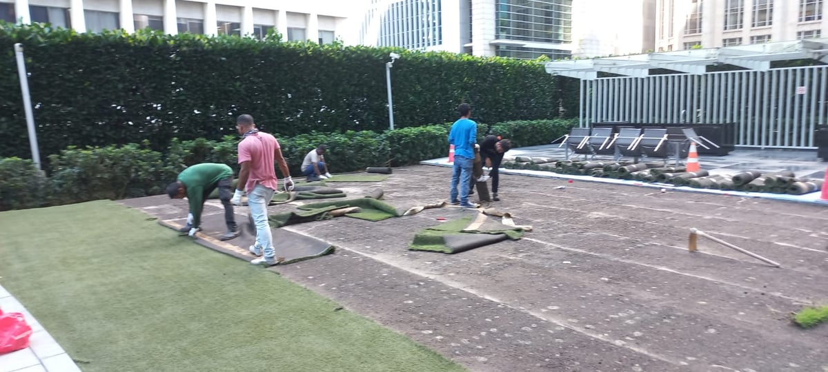 The ibuild team stripping out and rolling up the old artificial grass at One Shenton