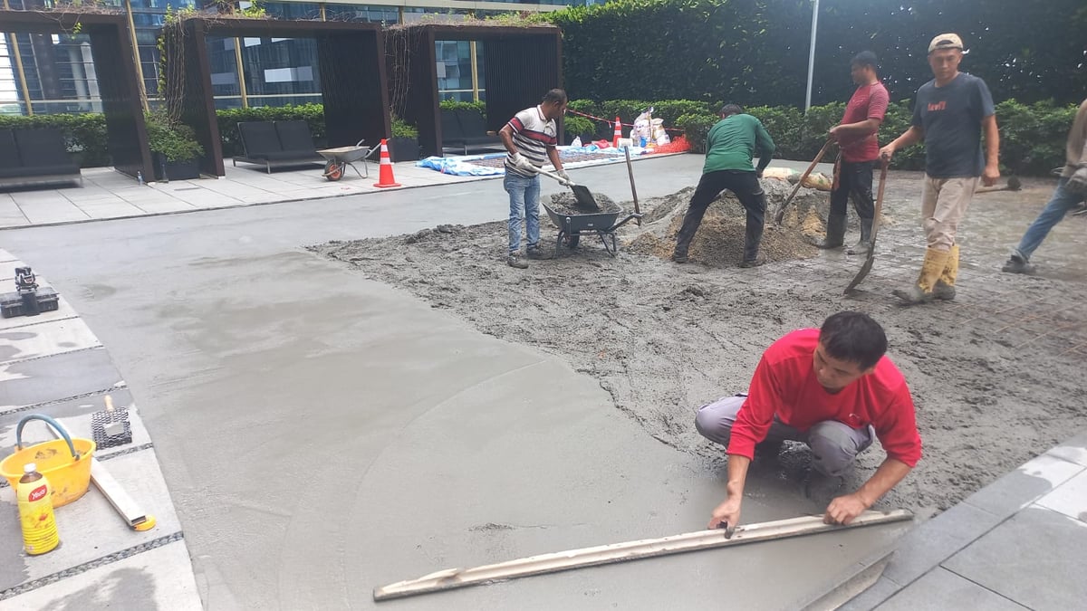 The ibuild team laying and levelling the cement screed to an even fall at One Shenton