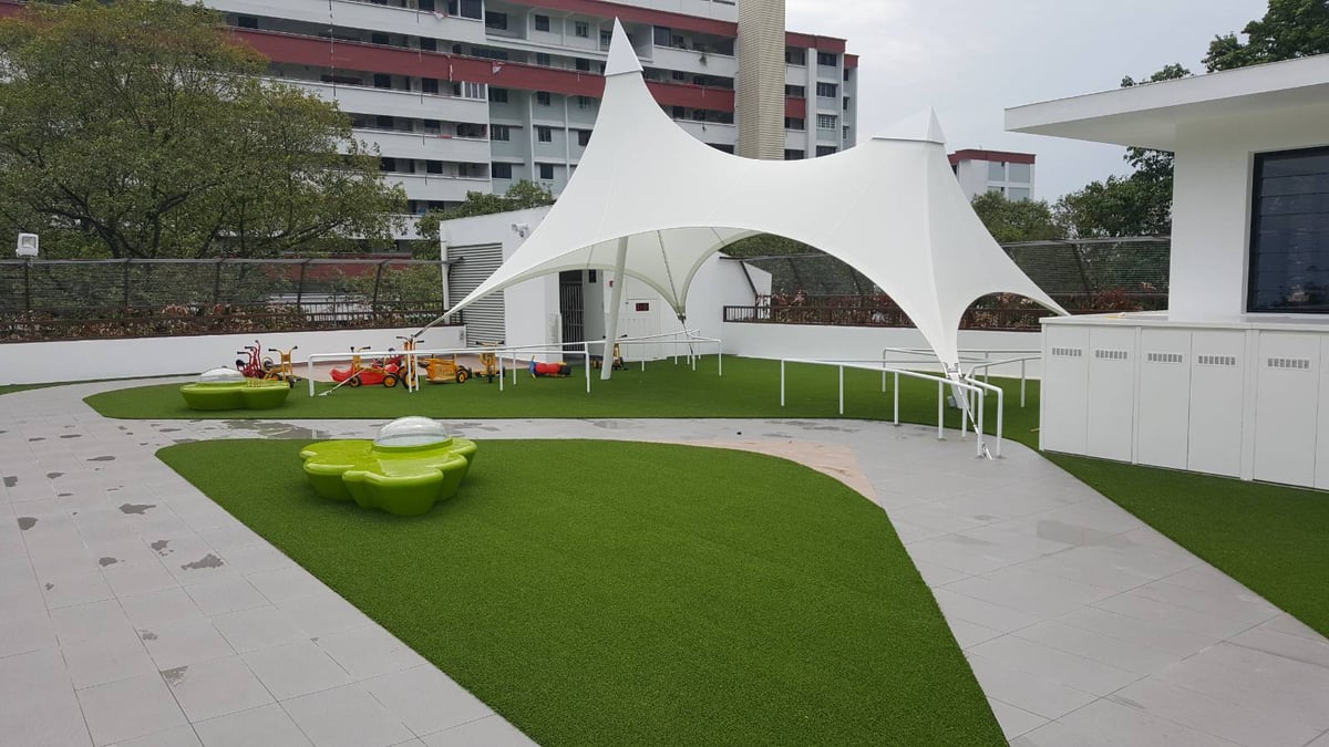 Shade sail over an artificial grass play area at PCF Sparkletots Woodlands rooftop