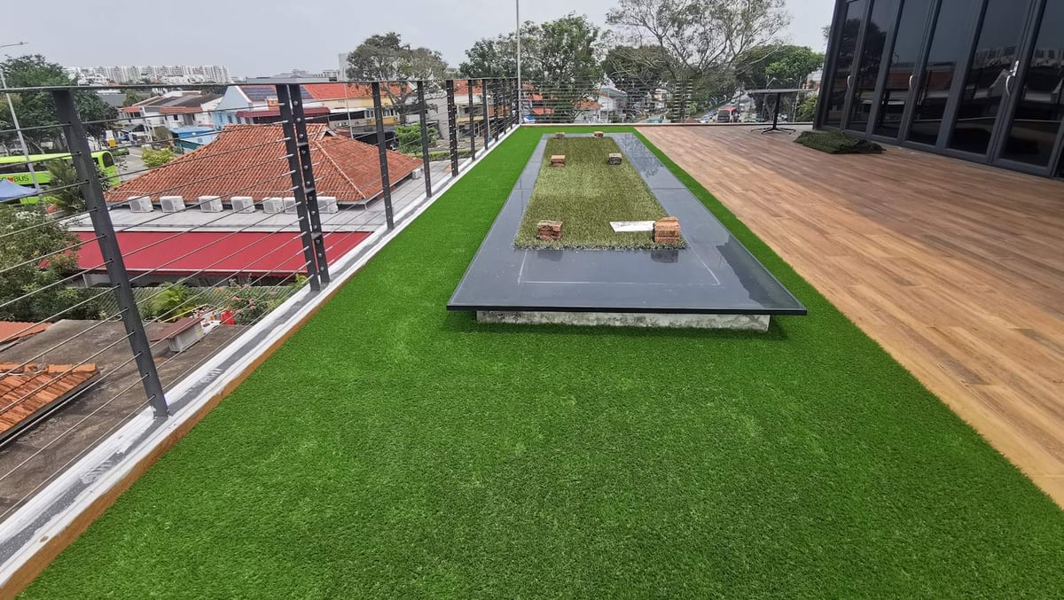 Rooftop reflecting pool set into synthetic grass with a timber deck at Serangoon Garden Way