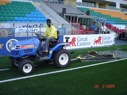 Tractor combing the pitch with brush and drag-net to stand the fibres at Jalan Besar Stadium, February 2009