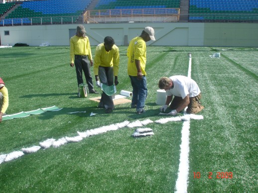 The team inlaying the white line markings into the pitch at Jalan Besar Stadium, February 2009
